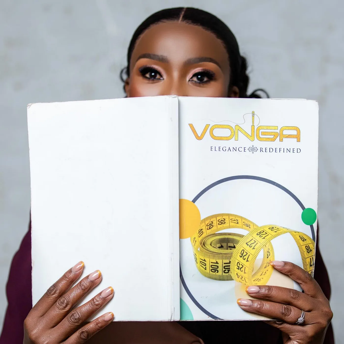 A Vonga designer holding the atelier's measurement portfolio